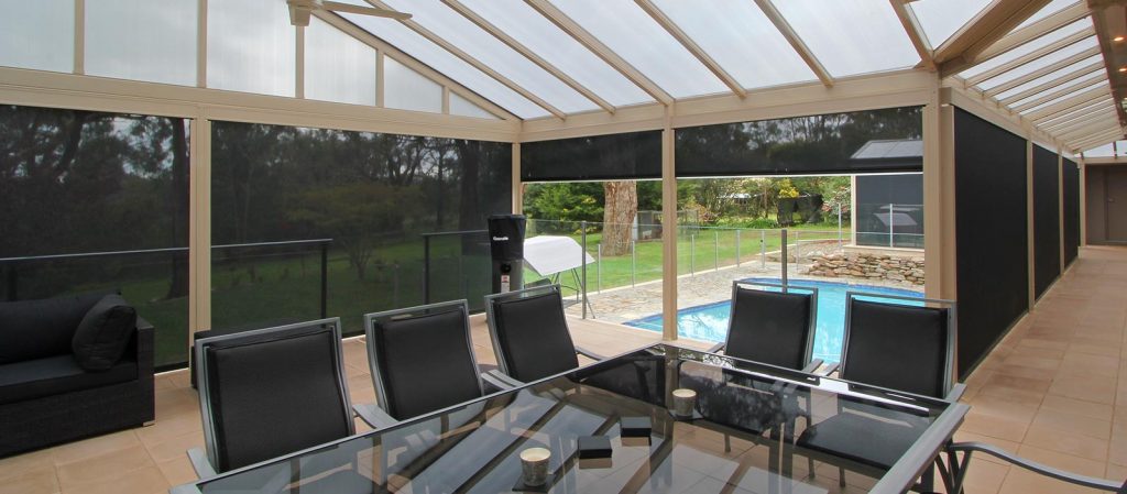 outdoor blinds in a pergola looking out over a swimming pool