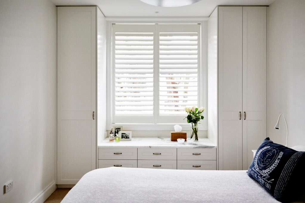 Bedroom with plantation shutters installed.